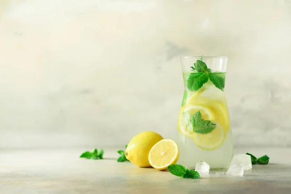 Desintoxicação de água com hortelã, limão sobre fundo cinza. Banner com espaço de cópia, bokeh luz solar. Limonada cítrica. Fruta de verão água infundida. Coquetel caseiro refrescante, foco seletivo . — Fotografia de Stock