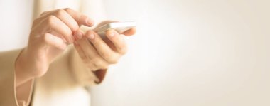 Kadın el cep telefonu açık krem renkli kopya alanı ile sakin ol. Afiş. İş, çalışma, uzaktan çalışma, her zaman kavramı bağlayın. Smartphone.
