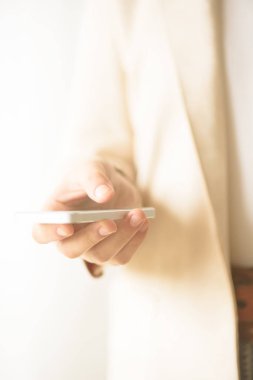 Kadın el cep telefonu açık krem renkli kopya alanı ile sakin ol. İş, çalışma, uzaktan çalışma, her zaman kavramı bağlayın. Smartphone.