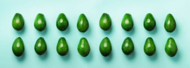 Mavi zemin üzerine yeşil avokado desen. Afiş. Üstten görünüm. Pop sanat tasarım, yaratıcı yaz gıda kavramı. Organik avocadoes en az daire yatıyordu tarzı.