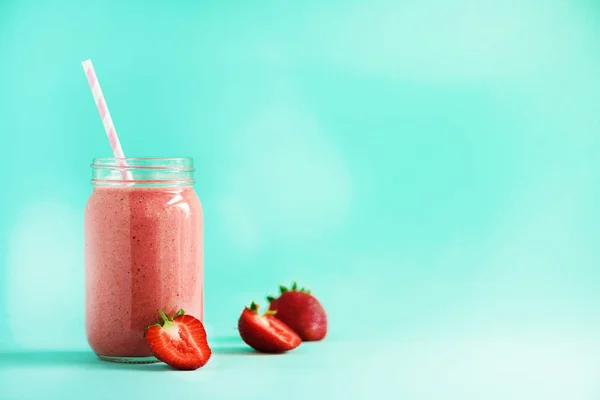 Bottle with vegan strawberry smoothie on blue background with copy space. Summer food concept, vegan diet. Pink smoothie with fresh berries — Stock Photo, Image