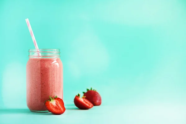 Botella con batido de fresa vegana sobre fondo azul con espacio para copiar. Concepto de comida de verano, dieta vegana. Batido rosa con bayas frescas — Foto de Stock