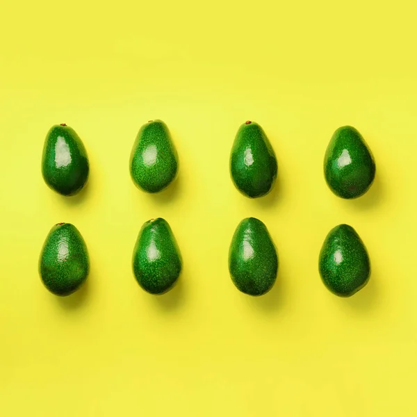 Sarı zemin üzerine yeşil avokado desen. Kare ürün. Üstten görünüm. Pop sanat tasarım, yaratıcı yaz gıda kavramı. Organik avocadoes en az daire yatıyordu tarzı. — Stok fotoğraf