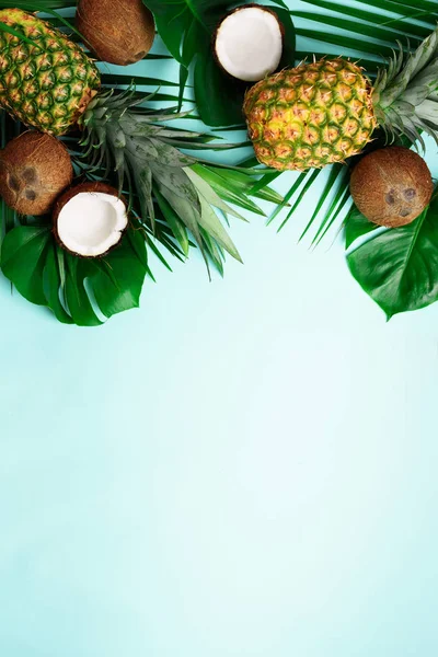 Egzotikus ananász, érett kókuszdiót, trópusi Pálma- és zöld monstera elhagyja a kék háttér és a szöveg copyspace. Kreatív elrendezés. Nyári koncepció. Lapos feküdt, top view — Stock Fotó