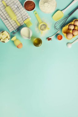 Malzemeler - tereyağı, şeker, un, yumurta, yağ, kaşık, oklava, fırça, çırpma teli, havlu mavi arka plan üzerinde pişirme. Ekmek yiyecek çerçeve, kavram yemek. Görünümü en çok, uzay kopyalayın. Düz yatıyordu