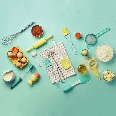 Fırında vakti geldi. Malzemeler - tereyağı, şeker, un, yumurta, yağ, kaşık, oklava, fırça, çırpma teli, havlu mavi arka plan üzerinde pişirme. Ekmek yiyecek çerçeve, kavram yemek. Görünümü en çok, uzay kopyalayın. Düz yatıyordu