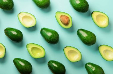 Mavi arka plan üzerinde avokado desen. Üstten Görünüm. Afiş. Pop sanat tasarım, yaratıcı yaz gıda kavramı. Yeşil avocadoes, en az düz stil yatıyordu.