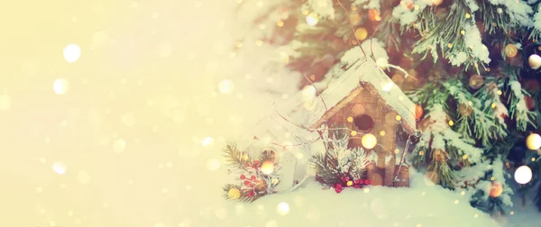 Karácsonyi háttér a fából készült ház, a jegenyefenyő-fák, a hó és a fényhatások. Új év koncepció. Hideg tél időjárás. Másolja a hely — Stock Fotó