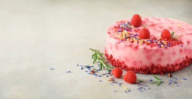 Taze çilek, biberiye ve gri beton zemin üzerine kuru çiçekler ile lezzetli frambuazlı pasta. Alan metni kopyalayın. Vejetaryen, vegan gıda kavramı.