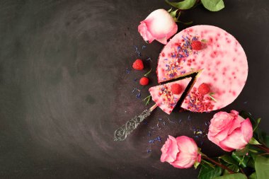 Pembe güller ve taze çilek, biberiye, karanlık vintage zemin üzerine kuru çiçekler ile lezzetli ahududu cake. Alan metni kopyalayın. Vejetaryen, vegan gıda kavramı.