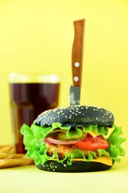 Fast food afiş. Sulu et Burger Peynirli, Sarı zemin üzerine marul. Yemek götürün. Sağlıksız beslenme kavramı kopya alanı ile.