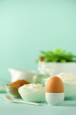 Fırında vakti geldi. Malzemeler - tereyağı, şeker, un, yumurta, yağ, kaşık, fırça, çırpma teli, süt mavi arka plan üzerinde pişirme. Ekmek yiyecek çerçeve, kavram yemek. Kopya alanı.