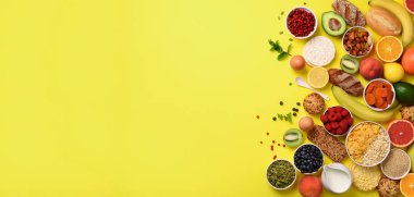 Organik gıda çerçeve. Afiş. Sağlıklı kahvaltı malzemeler. Yulaf ve Mısır gevreği, yumurta, fındık, meyve, çilek, kızarmış ekmek, süt, yoğurt, portakal, muz, Sarı zemin üzerine şeftali. Üstten Görünüm, kopya alanı