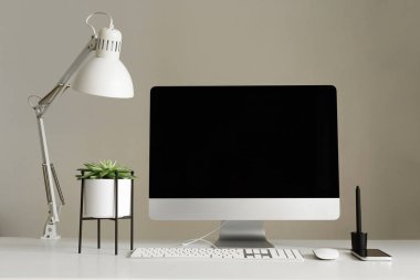 Tasarımcı çalışma alanı. Minimalist ev ofis. Boş ekran masaüstü bilgisayar, Mockup masaüstü bilgisayar, lamba, grafik tablet, klavye, fare, kalem, beyaz masa üzerine etli bitki. Kopya alanı.