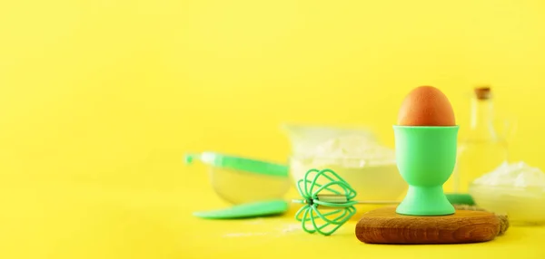 Turquoise and yellow cooking utensils on bright background. Food ingredients. Macro of eggs. Cooking cakes and baking bread concept. Copy space. Banner.