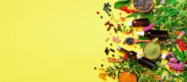 Tıp bütünsel yaklaşım. Sağlıklı gıdaya beslenme, diyet, şifalı otlar ve çiçekler. Zerdeçal, kurutulmuş lavanta, spirulina tozu ahşap kase, taze meyveler, omega asit kapsül.