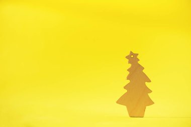 Kopya alanı Sarı zemin üzerine ahşap Noel ağacı. Yeni yıl partisi. Kış tatil kavramı. Tebrik kartı en az tarzı. Eko Dostu dekorasyon.