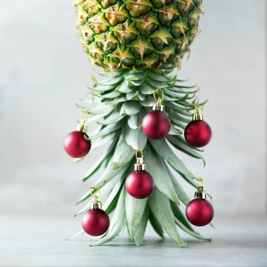 Yaratıcı Noel ağacı ananas ve kırmızı önemsiz şey kopya alanı gri beton zemin üzerine yapılmış. Tebrik kartı, dekorasyon yılbaşı partisi için. Tatil kavramı. Kare kırpma.