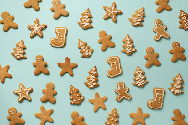 Домашнее рождественское печенье на синем фоне. Образец пряничных человечков, снежинки, звезды, ели, формы сапог. Новогодняя концепция
.