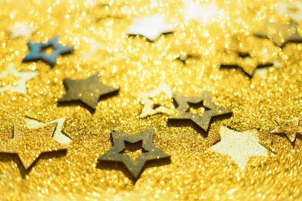 Fête de Noël. Contexte abstrait pour la fête du nouvel an. Patter of gold stars with lights, bokeh. étoiles paillettes dorées sur texture jaune miroitante — Photo