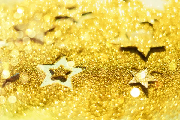 Celebración de Navidad. Fondo abstracto para la fiesta de año nuevo. Patter de estrellas doradas con luces, bokeh. Estrellas de brillo dorado sobre textura de brillo amarillo — Foto de Stock