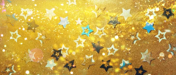 Estrelas azuis e amarelas no fundo dourado com bokeh. Textura para o ano novo, aniversário, festa de chá de bebê. Padrão criativo. Banner — Fotografia de Stock