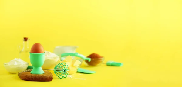 Turquoise and yellow cooking utensils on bright background. Food ingredients. Macro of eggs. Cooking cakes and baking bread concept. Copy space. Banner.