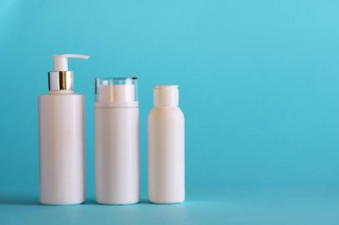 Mavi arka planda fotokopi alanı olan beyaz kozmetik tüpleri. Cilt bakımı, vücut bakımı, güzellik konsepti. Pankart