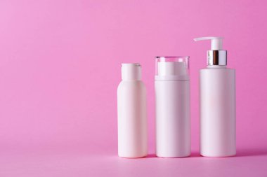 Kopya alanı ile pembe arka plan üzerinde beyaz kozmetik tüpler. Cilt Bakımı, vücut bakımı, güzellik kavramı.