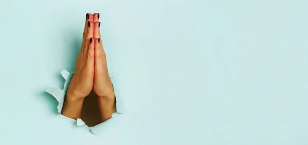 青い紙の背景を引き裂かれた若い女性の手を祈る キリスト教 礼拝の概念 コピースペース付きバナー — ストック写真