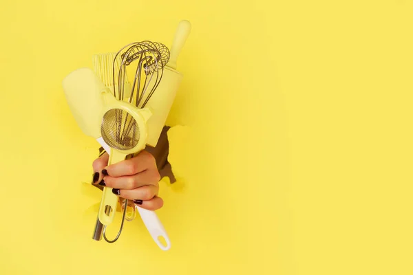 Mano Mujer Sosteniendo Utensilios Cocina Sobre Fondo Amarillo Herramientas Para —  Fotos de Stock