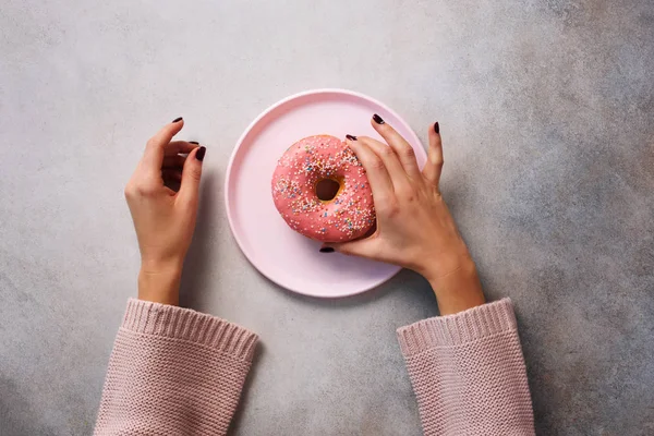 Female Hands Holding Donut Pink Plate Stone Background Top View — Stock Photo, Image