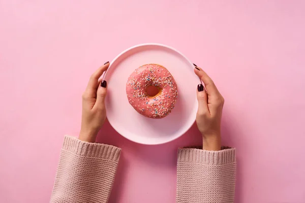 Female Hands Holding Donut Plate Pink Background Top View Flat — Stock Photo, Image