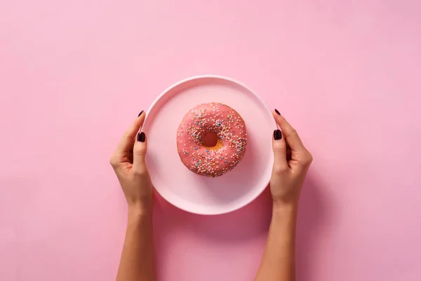 Female Hands Holding Donut Plate Pink Background Top View Flat — Stock Photo, Image