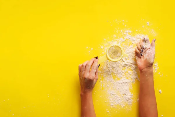 Female hand holding sieve flour on yellow background. Baking and cooking concept. Banner with copy space. — 스톡 사진