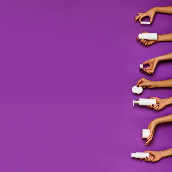 Manos femeninas sosteniendo botellas de cosméticos blancos - loción, crema, se — Foto de Stock