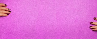 Kadın eli boş, parlak, menekşe kağıtlı bir arka plan tutuyor. Makyöz, güzellik konsepti. Güzellik salonu reklam afişi ve bilgi için fotokopi alanı.