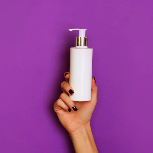 Жіночі Руки Тримають Білу Косметичну Пляшку Фіолетовому Фоні Прапор Догляд — стокове фото