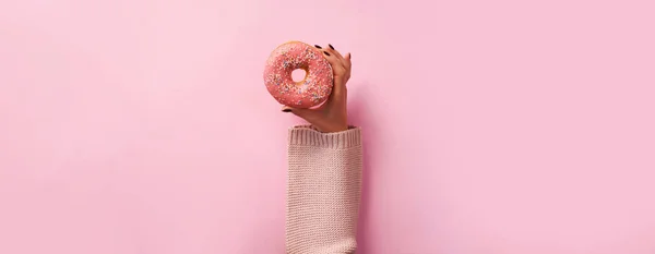 Руки Женщины Держат Пончик Розовом Фоне Вид Сверху Плоский Сладкое — стоковое фото