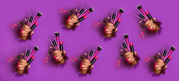 Pattern of woman hands with professional cosmetic tools for make up: brushes, mascara, lipstick, eyelash curler on violet background. Beauty concept. Banner for cosmetics sale. Copy space.