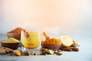 Gri arka plan üzerinde zerdeçal sıcak çay için malzemeler. Limon, zencefil, tarçın, zerdeçal ile sağlıklı Ayurveda içki. Çare artırılması bağışıklık.