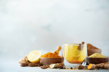 Gri arka plan üzerinde zerdeçal sıcak çay için malzemeler. Limon, zencefil, tarçın, zerdeçal ile sağlıklı Ayurveda içki. Çare artırılması bağışıklık.