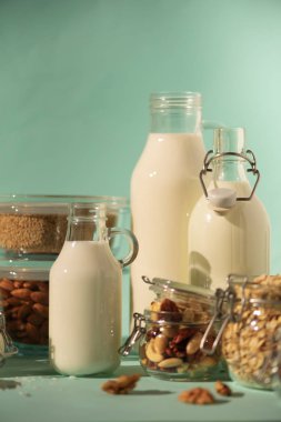 Vegan yerine süt süt. Cam şişe süt süt ve malzemeler üzerinde kopya alanı ile mavi arka plan ile. Temiz yemek, süt-free, vegan, Anti-Dostu, sağlıklı gıda kavramı.