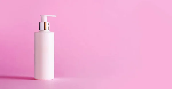 Witte fles hydraterende lotion op roze achtergrond met kopie ruimte. Minimalisme stijl. Huid zorg, lichaamsbehandeling, beauty concept — Stockfoto