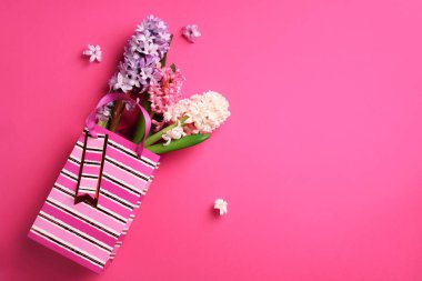 Taze pembe, beyaz, mor sümbül çiçekler punchy pastel arka plan üzerinde alışveriş çantası. Kopya alanı ile banner. Bahar, yaz ve Bahçe kavramı. Yaratıcı düzeni. Üstten Görünüm, düz yatıyordu.