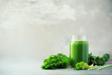 Gri beton zemin üzerine yeşil kereviz güler yüzlü bir şişe. Kopya alanı ile banner. Kare ürün. Taze meyve suyu Detoks için. Vegan, alkalin sağlıklı beslenme kavramı