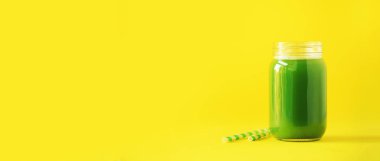 Sarı zemin üzerine yeşil kereviz güler yüzlü bir şişe. Kopya alanı ile banner. Taze meyve suyu Detoks için. Vegan, alkalin sağlıklı beslenme kavramı