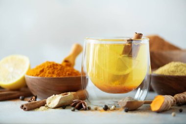 Gri arka plan üzerinde zerdeçal sıcak çay için malzemeler. Limon, zencefil, tarçın, zerdeçal ile sağlıklı Ayurveda içki. Çare artırılması bağışıklık