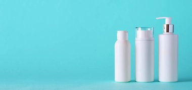 Mavi arka planda fotokopi alanı olan beyaz kozmetik tüpleri. Cilt bakımı, vücut bakımı, güzellik konsepti. Pankart