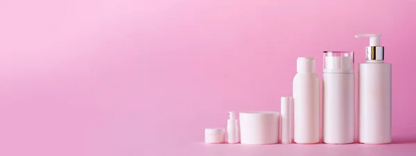 Білі косметичні трубки на рожевому фоні з простором копіювання. Догляд за шкірою, лікування тіла, концепція краси. Банер — стокове фото